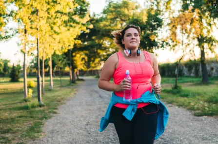 Priya on an evening run with headphones around her neck and a water bottle