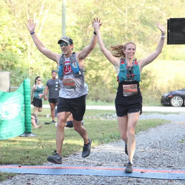 Hal finishing a trail marathon, arms raised